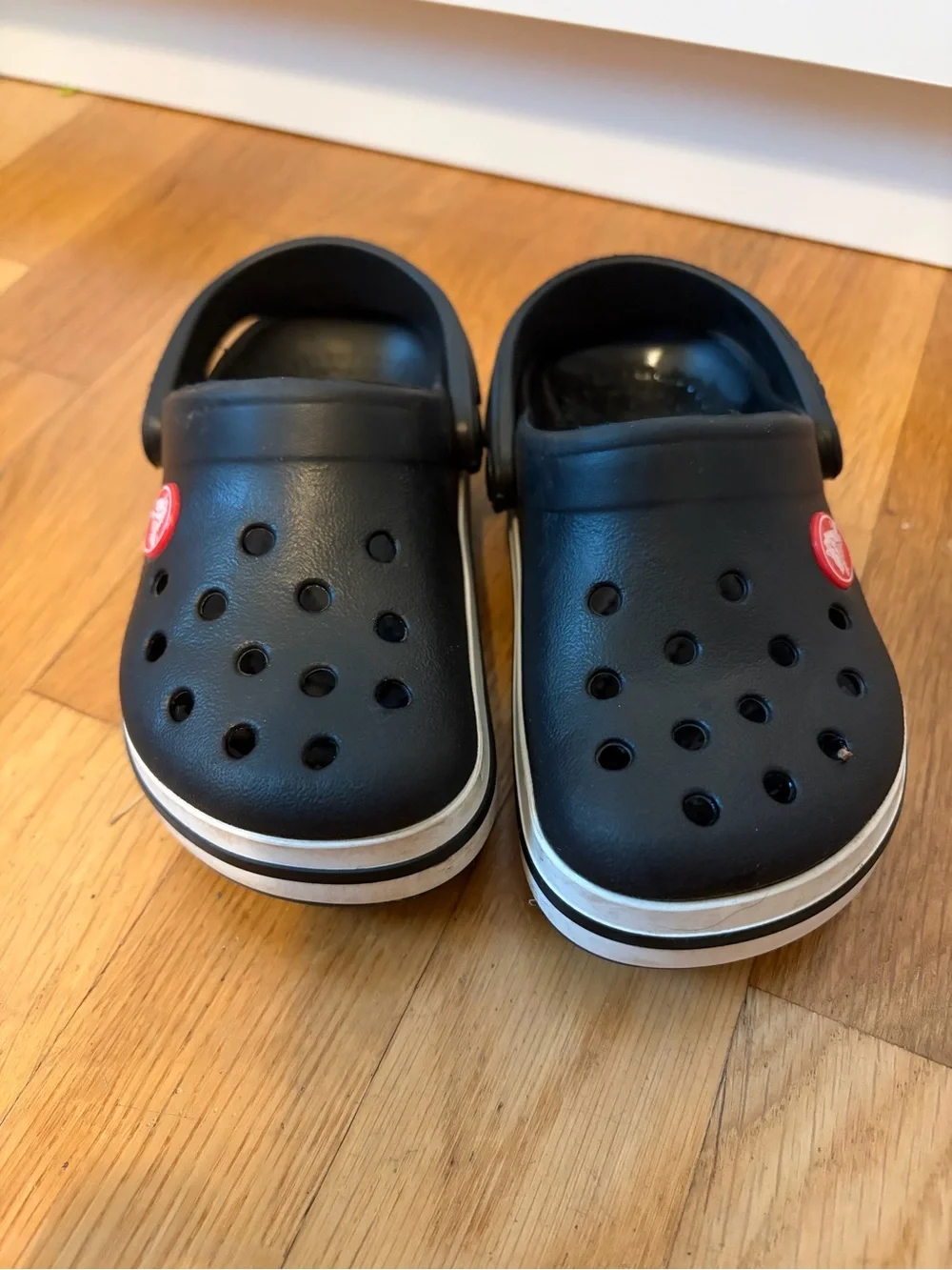 Kid’s black Croc slip on shoe with white band size 8